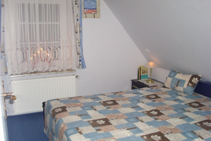 Das Elternschlafzimmer mit
Adventsbogen am Fenster.