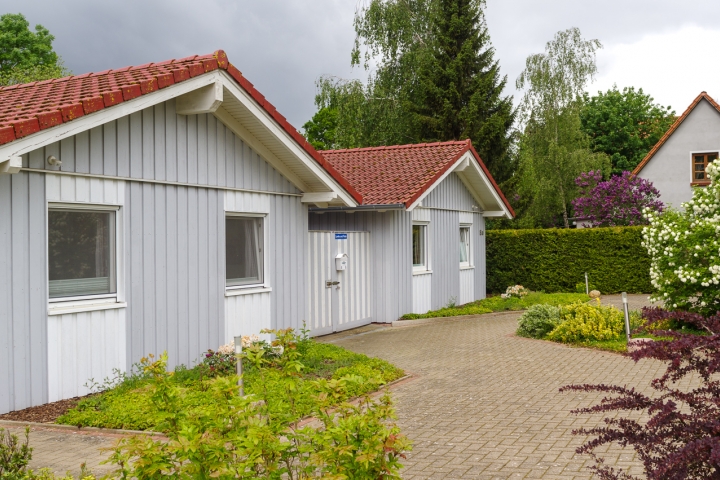 Vorderseite Haus mit Parkplätzen und abgeschlossenem Innenhof