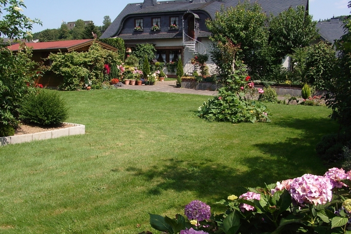 Eifelferienwohnung I Eingang, Gartengrundstück mit Gartenhaus und schattiger Veranda.
