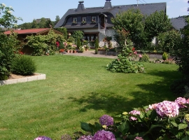 Eifelferienwohnung I Eingang, Gartengrundstück mit Gartenhaus und schattiger Veranda.  