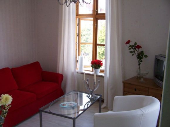 Appartements Wismar | Wohnzimmer mit rotem Sofa.
2 Fenster, zur Runden und
zur Frischen Grube. Liebevoll
eingerichtet.