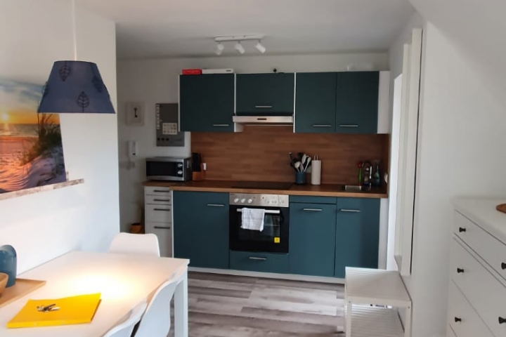Essbereich mit Küchenzeile und Zugang zum Balkon