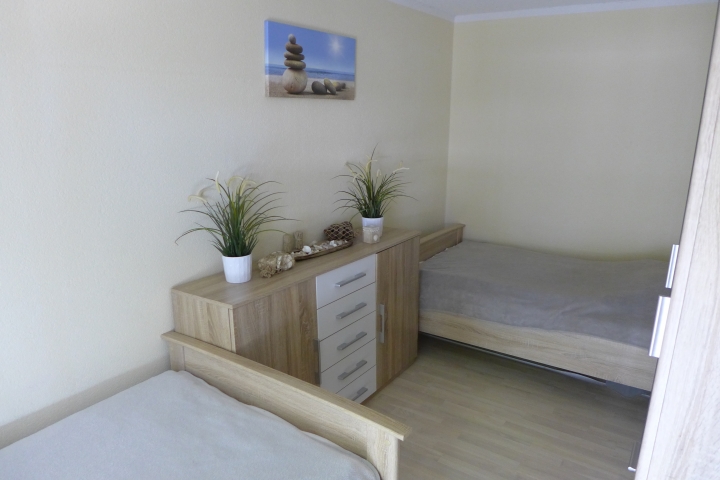Im Schlafzimmer sind 2 Einzebetten, Kommode und ein Kleiderschrank
