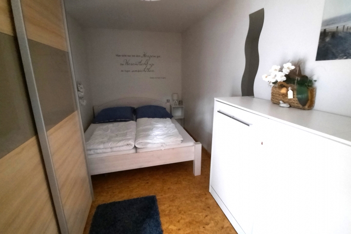 Schlafzimmer mit Kleiderschrank (links) und Schrankbett (rechts)