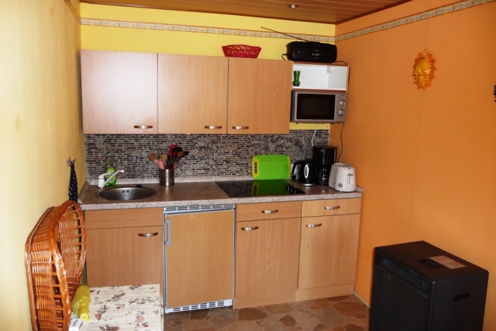 Ihr Küchenbereich mit Töpfen, Geschirr, Microwelle, Kaffeeautomat, Toaster, Wassererhitzer