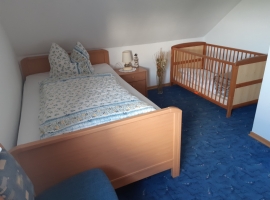 Schlafzimmer mit Bett (1,20m breit) und Kinderbett