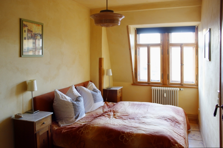 Schlafraum mit großem Doppelbett und Blick in den Garten 