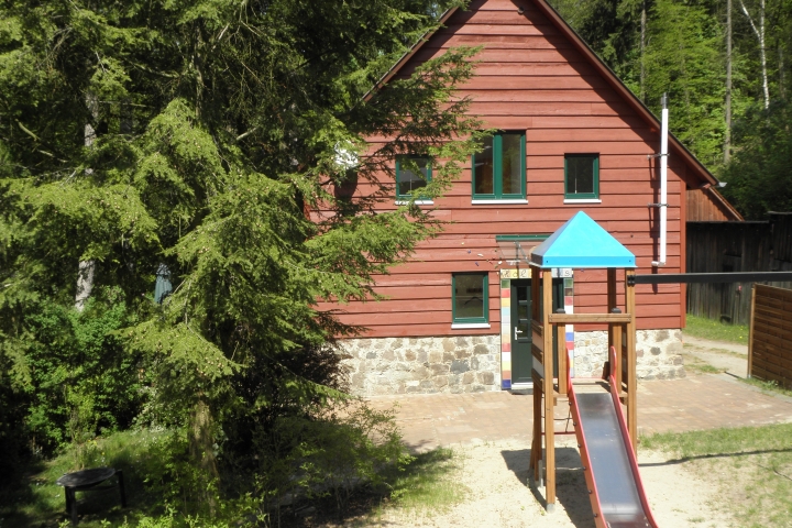 Holzhaus mit Sandspielplatz