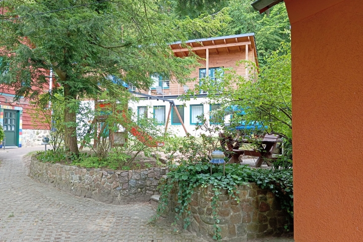 Eche H. Morgenrot, im Hintergrund das Holzhaus u. das Sonnenhaus mit dem Spielplatz