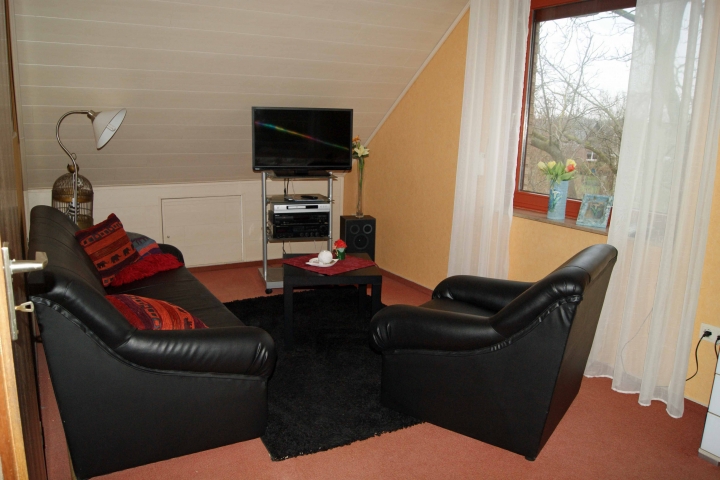 Sitzecke im großen Schlafzimmer mit Fernseher und Musikanlage und DVD Player