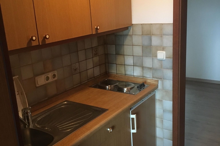 Küche mit Kühlschrank, 2-Plattenherd, Wasserkocher, Kaffeemaschine.