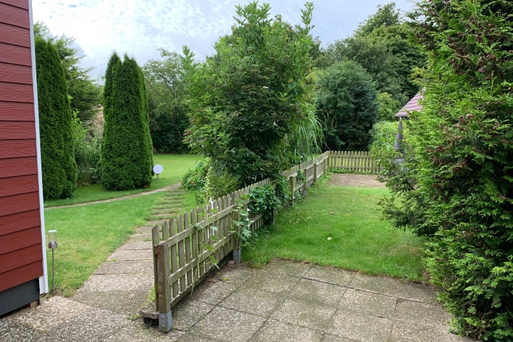 Blick in den Garten und auf die Terrassen von Ferienhaus und Apartment
