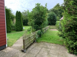 Blick in den Garten und auf die Terrassen von Ferienhaus und Apartment