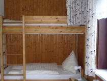 Schlafzimmer mit Einzelbett und überbautem Hochbett