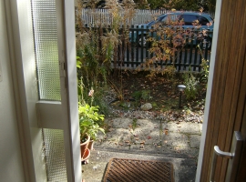 Blick in den Vorgarten aus geöffneter Haustür