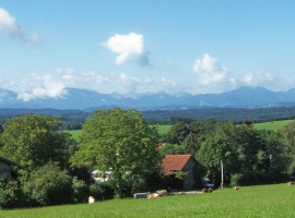 Blick auf Haus und Alpenkette