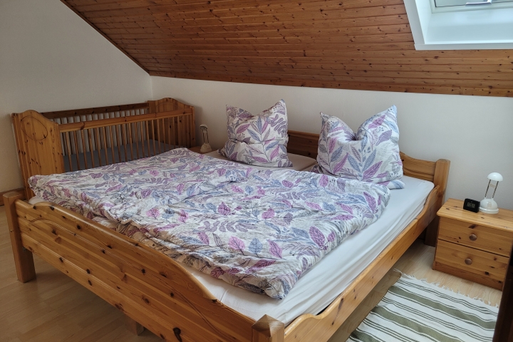 Schlafzimmer mit Doppelbett und feststehendem Kinderbett.