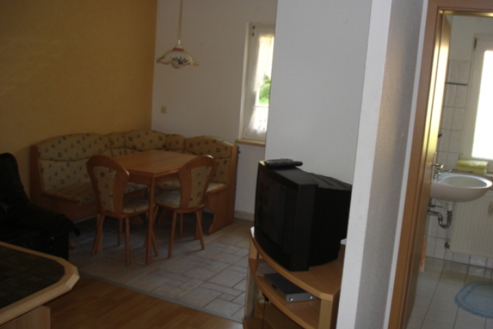 Blick vom Eingang mit Sitzecke in der Küche, Wohnzimmer mit Couchtisch 