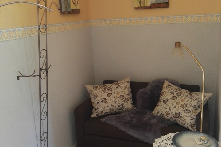 Ecke im Flur mit kleinem Schlafsofa und Garderobe