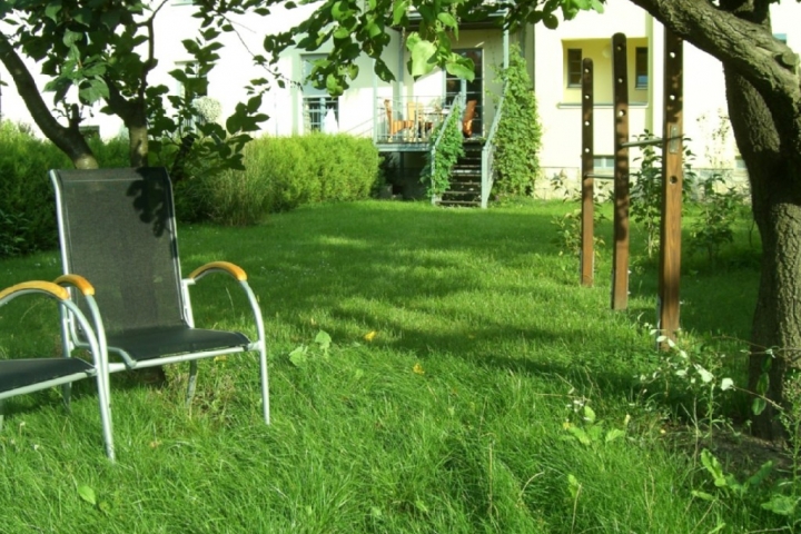 Blick von Ihrem Garten zur weinumrankten Terasse im Frühling.