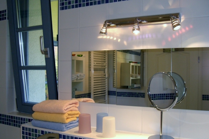 Das Bad mit Wanne und Dusche hat zwei Fenster.
