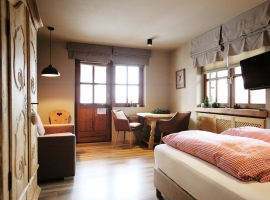 Wohn- und Schlafraum mit Doppelbett und Sitzecke