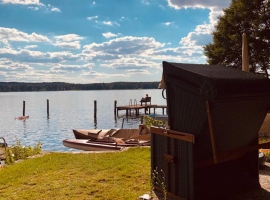 Blick vom Ufer des Grundstücks auf den See. 
Strandkorb für die Urlauber 