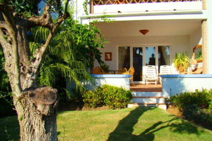 Blick von Pool auf Wohnung mit privatem Garten