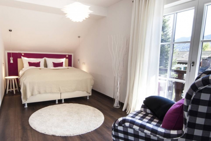 Schlafzimmer mit Zuganbg zum Balkon und Lesesessel