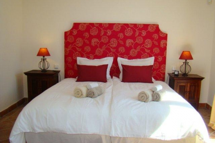 Hauptschlafzimmer mit grossem Doppelbett und frontalem Pool- und Meerblick