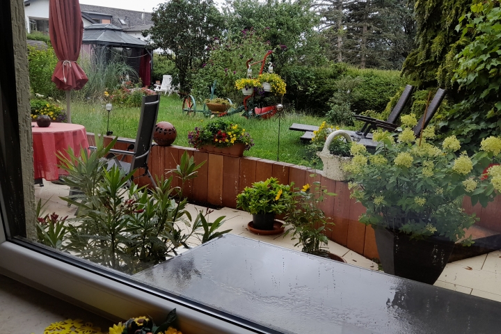 Blick aus Schlafzimmer auf Terrasse und Liegewiese