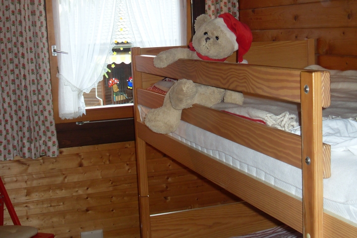 der Teddy fühlt sich im Kinderzimmer auf dem Etagenbett pudelwohl