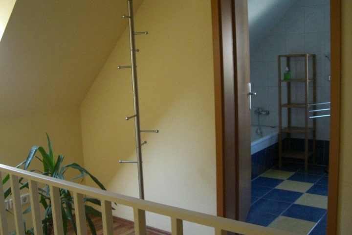Blick vom Treppenhaus ins Bad mit Wanne und Dusche