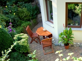 Terrasse mit Gartenmöbeln aus Massivholz (Südseite)