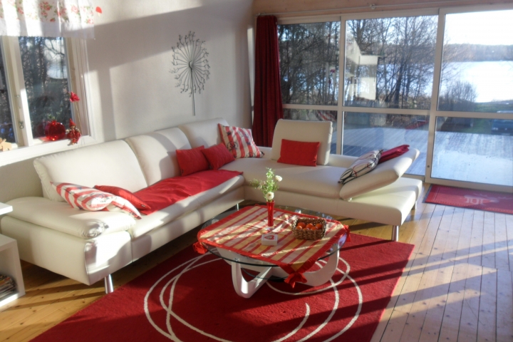 Großzügiges Wohnzimmer mit Ledereckgruppe und Blick zum See Unnen
