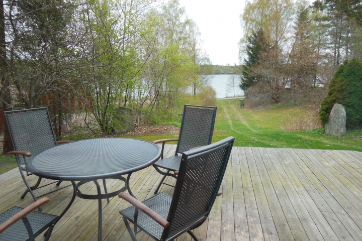 Die große Holzterrasse mit neuen Gartenmöbeln bietet Blick zum See Unnen.