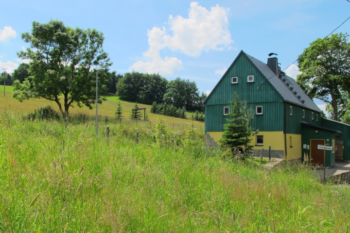 Grünes Ferienhaus und umliegende Landschaft im Mai