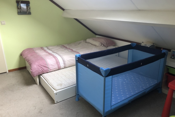 Kinderzimmer mit drei Einzelbetten und einem Kinderreisebett