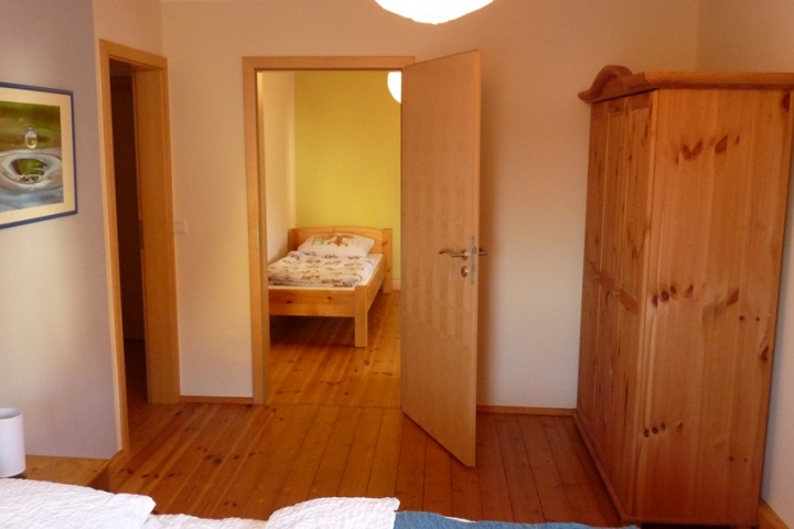 Zimmer mit Doppelbett, Blick durch Verbindungstür in Zimmer mit Einzelbett, je eine Tür zum Korridor