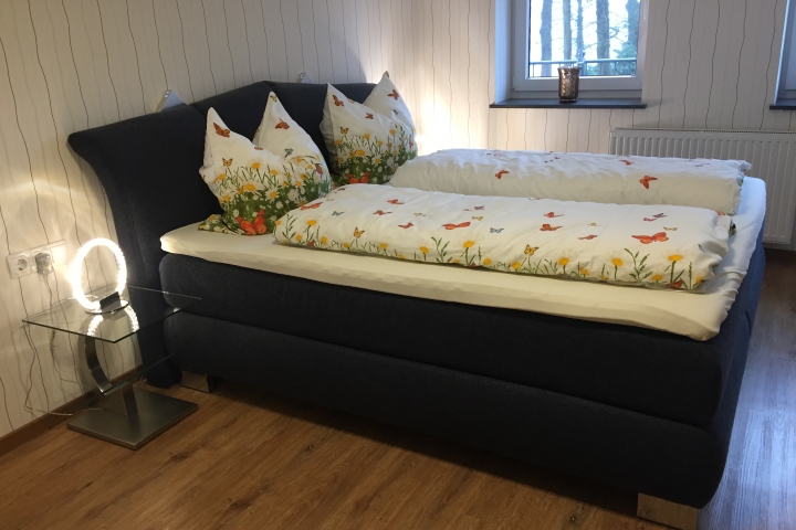 Schlafzimmer mit Boxspringbett (bei Bedarf mit Babybett) .