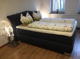 Schlafzimmer mit Boxspringbett (bei Bedarf mit Babybett) .