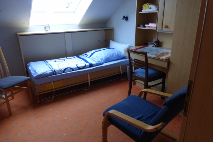 Schlafzimmer mit Schrankbett, Kleiderschrank und Schreibplatz