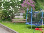 Der Spielplatz mit Trampolin und Schaukel.