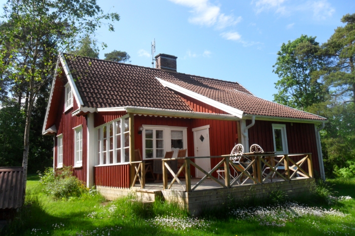 Haus mit Hintereingang und Terrasse, teilweise überdacht.