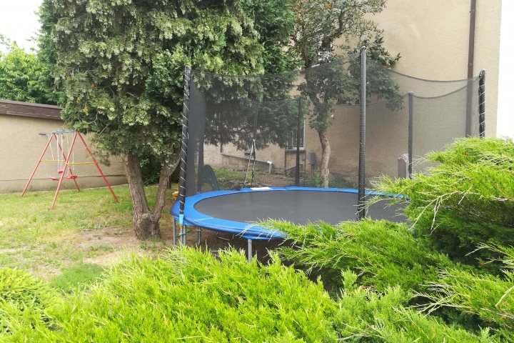 Gartenbereich mit Trampolin und Kinderschaukel
