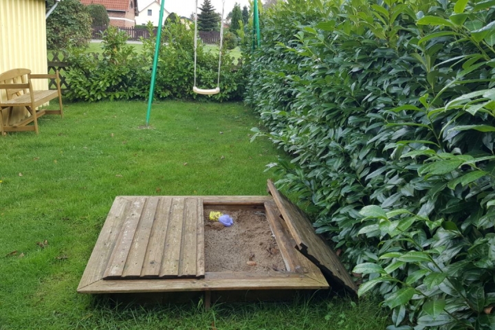 Sandkiste und Schaukel im Spielgarten