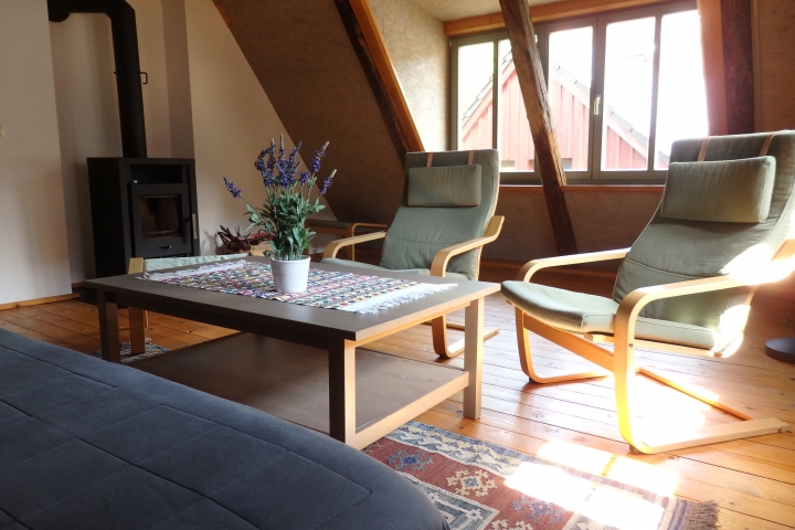 Wohnzimmer mit Kaminofen und Schlafsofa
