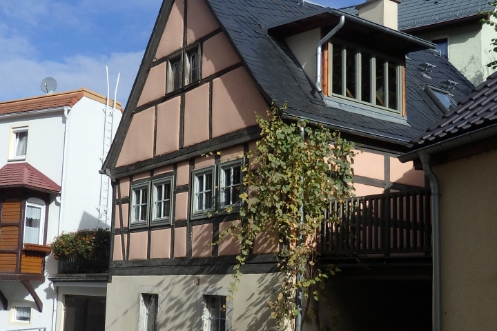 rechts vom Haus die Terrasse, darunter der Carport