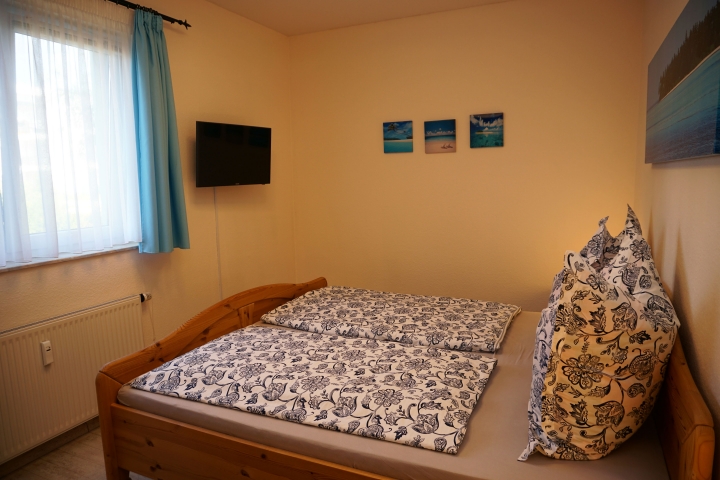 Schlafzimmer mit TV und hohen Betten