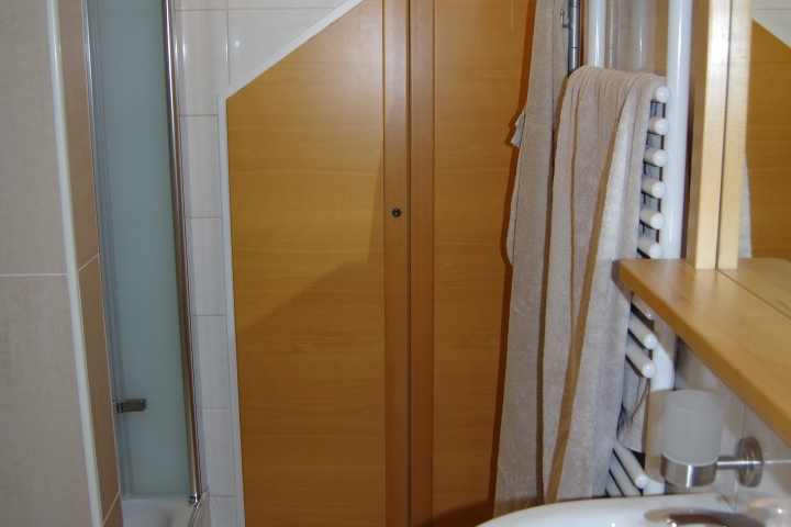 Studiowohnung - Herzmuschel Bad - Waschbecken, Blick auf die Abstellkammer und Dusche